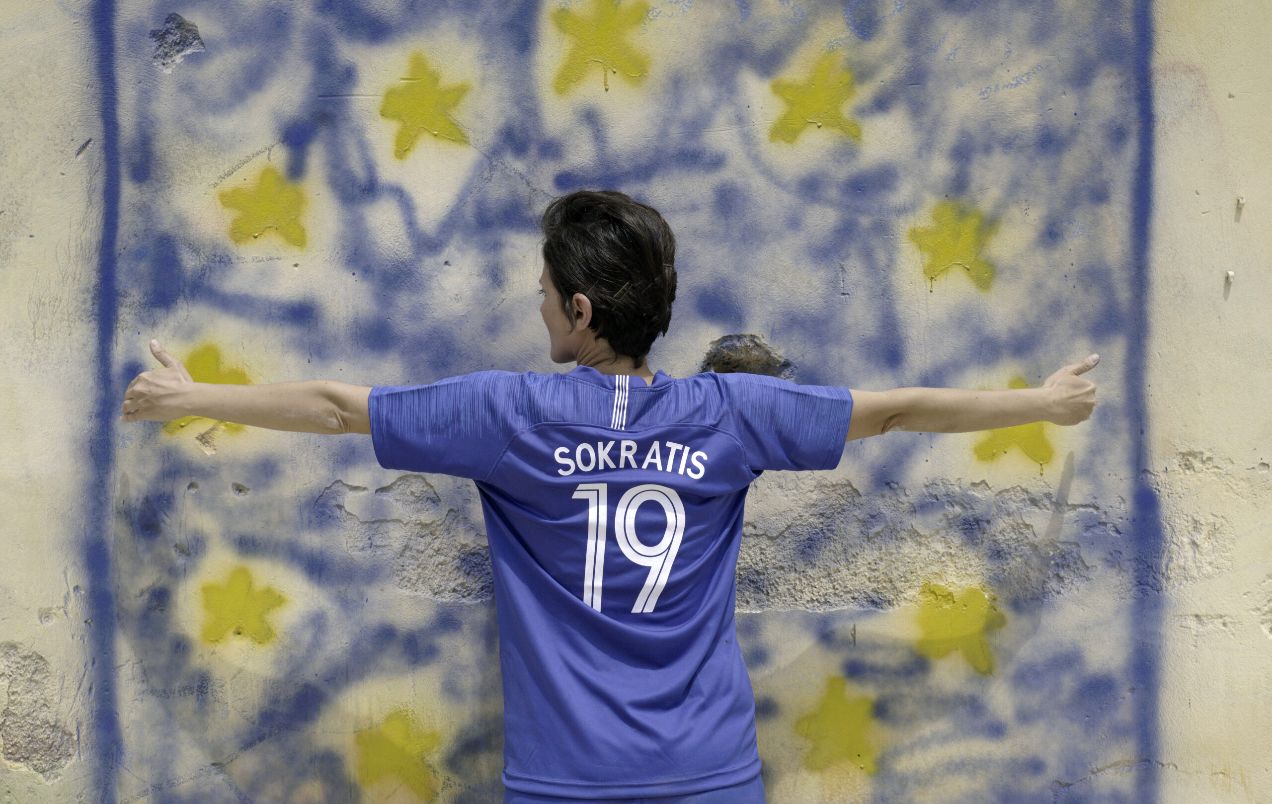 Sokratis, dettaglio bandiera, Produzione on the Breadline, video 4K, 5’ 10”, colori foto su carta Hahnemülhe, 80x100 cm, 2019